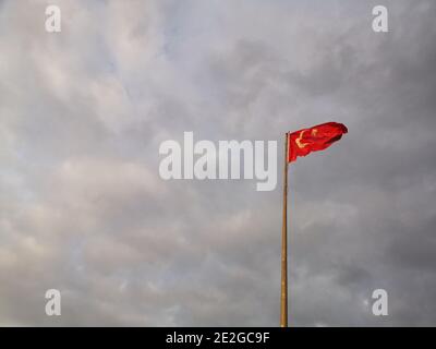 Drapeau de la Turquie sur le mât agitant dans le vent contre ciel nuageux Banque D'Images