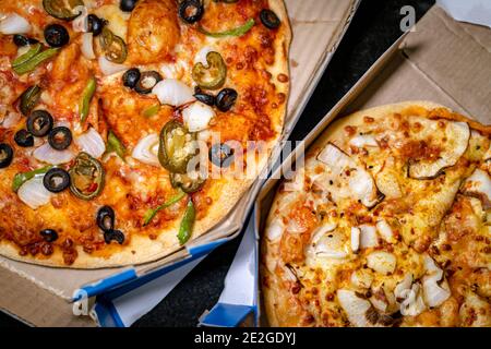 Vue de dessus de deux pizzas végétariennes différentes dans des boîtes à emporter Banque D'Images