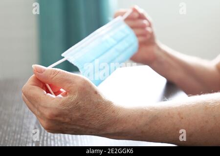 Femme âgée avec un masque médical dans les mains. Protection contre les coronavirus pour les personnes âgées Banque D'Images