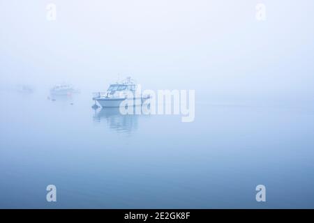 Des bateaux amarrés à l'estuaire de la Swale dans le nord du Kent un matin brumeux. Banque D'Images