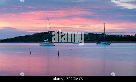 Bateaux sur l'estuaire du Swale dans le Kent au coucher du soleil. Prise de Harty Ferry, Faversham. Banque D'Images