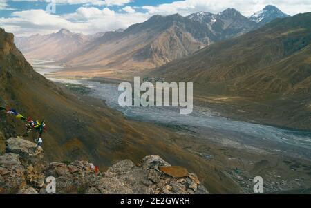 La rivière Spiti traverse la vallée du Spiti et flanque les drapeaux de prière himalayas et bouddhistes lors d'une belle journée d'été près de Kaza, Himachal Pradesh, Inde. Banque D'Images