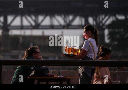 Sydney, Australie. 14 janvier 2021. Une serveuse portant un masque sert de la bière dans un bar extérieur près de l'Opéra de Sydney, à Sydney, en Australie, le 14 janvier 2021. Mardi, la plus grande ville australienne de Sydney a enregistré cinq cas de COVID-19 acquis localement, les autorités ayant exhorté le public à être testé et à accroître l'ouverture et la transparence avec les traceurs de contact. Credit: Bai Xuefei/Xinhua/Alay Live News Banque D'Images