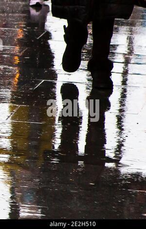 Reflet de la silhouette des pieds dans une flaque Banque D'Images