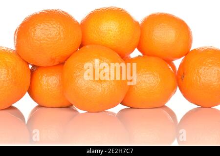 Quelques mandarines juteuses entières mûres d'orange vif, sur fond blanc. Le mandarin le plus proche, au premier plan. Banque D'Images