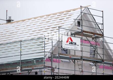 14 janvier 2021, Saxe, Klaffenbach : panneau publicitaire pour la construction de terrains devant un chantier de construction d'une nouvelle maison dans un développement enneigé. Photo: Jan Woitas/dpa-Zentralbild/ZB Banque D'Images