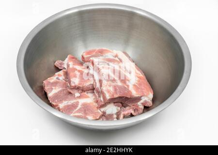 Côtes de porc douces de rechange dans un bol en acier inoxydable, image isolée sur fond blanc, vue de dessus côtes de porc fraîches de rechange. Banque D'Images