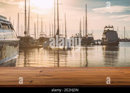 Espace vide de parquet en bois à la marina, arrière-plan flou de la mer, yachts et ciel de coucher du soleil. Le réchauffement semble vue sur le quai à bateaux. Banque D'Images