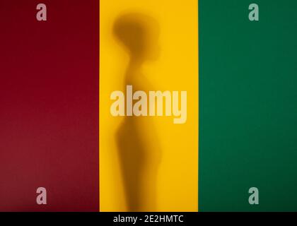 Mois de l'histoire des Noirs. Une ombre d'une femme africaine sur fond de papier rouge, jaune et vert. Copier l'espace. Banque D'Images