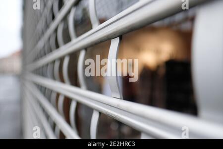 Leipzig, Allemagne. 14 janvier 2021. La grille de protection d'un magasin de mode fermé du centre-ville. Credit: Sebastian Willnow/dpa-Zentralbild/dpa/Alay Live News Banque D'Images