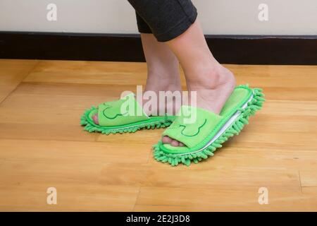 Gros plan des pieds de femme avec de mignons pantoufles debout sur parquet Banque D'Images