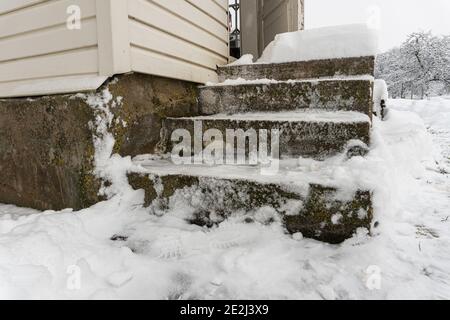 Porche en béton dégagé de neige en hiver et ouvrir une porte antique, maison de campagne en hiver Banque D'Images