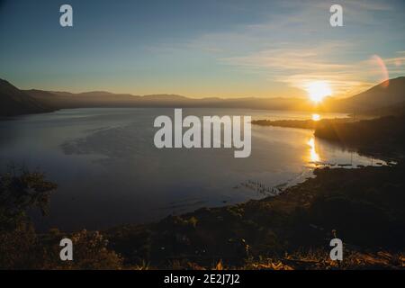 Lever du soleil sur le lac Atitlán le soleil se levant derrière les montagnes Et volcans - premiers rayons de soleil sur le beau lac À Sololá Guatemala Banque D'Images