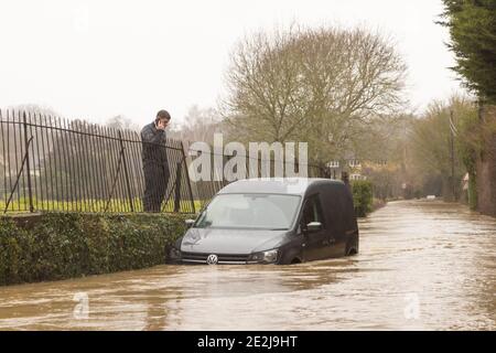 Un homme qui téléphonait pour obtenir de l'aide après que son véhicule s'est effondré sur une route inondée. Beaucoup Hadham, Hertfordshire 14 janvier 2021 Banque D'Images