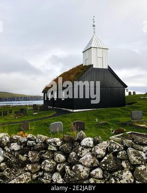 Sandoy, îles Féroé : église en bois noir de Sandur avec toit en herbe, qui a été rénovée après un incendie d'incendie. Banque D'Images