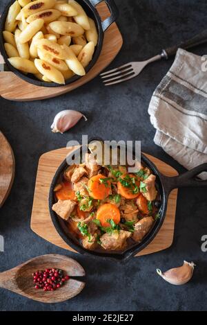 Viande de porc compotée (goulash) avec des carottes et des épices servies avec nouilles Banque D'Images