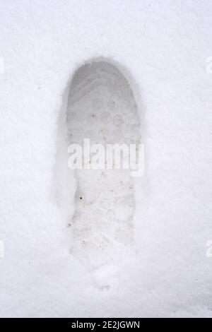 Vue en hauteur des empreintes humaines sur fond blanc de neige d'hiver. Banque D'Images