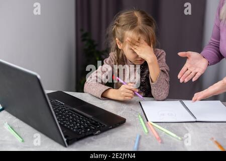 Les consoles d'une mère à son jeune fille quand elle se laisser décourager d'essayer de faire ses devoirs. Banque D'Images