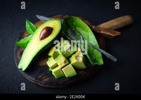 Fruits frais à l'avocat sur une planche en bois avec cuillère et couteau. Le concept de saine alimentation. Photographie alimentaire Banque D'Images