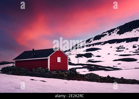 Maison en bois rouge typique de norvège près de la célèbre route de montagne d'Aurlandsvegen (Bjorgavegen) à Aurland, Norvège au coucher du soleil. Photographie de paysage Banque D'Images