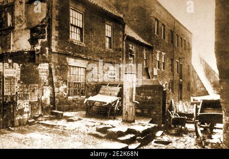 Alder's Waste Ghaut, Church Street et The Virgin Pump, Whitby Yorkshire comme c'était quand les marchands de charbon Harker's Jet Merchant et Stamp's avaient des locaux. La pompe publique vue ici portait l'inscription 'Antlia pro bono pupublico' (pour le bien public). La hording à gauche marque l'emplacement de l'ancienne Couronne et de l'ancre, maison publique. La cale existe toujours en 2021 Banque D'Images