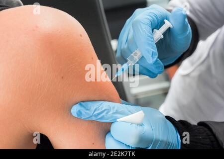 Les mains rapprochées, les infirmières sont des vaccinations aux patients en utilisant la seringue.Docteur vaccinant les femmes à l'hôpital. Banque D'Images