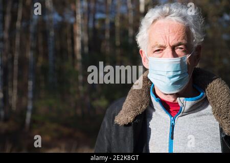 Homme âgé avec masque de visage dans la forêt naturelle Banque D'Images