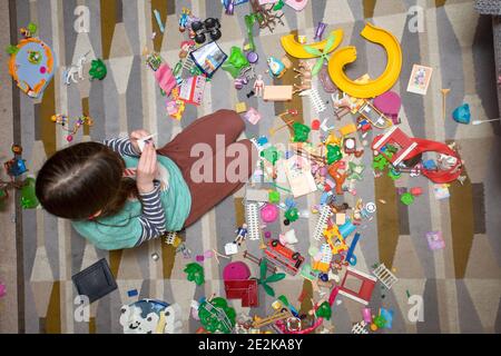 Jeune fille jouant avec playmobil sur le sol Banque D'Images