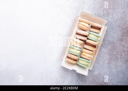 Macarons en boîte sur fond de pierre. Délicieux macarons français. Espace de copie, vue de dessus - image Banque D'Images