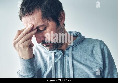 Maux de tête de gueule de bois, homme souffrant de douleurs sévères au front le matin après avoir consommé de l'alcool Banque D'Images