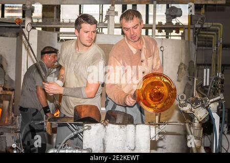 Deux glassmakers vase unique créatif dans la Moser Glass Factory en République tchèque. Transformer une masse chaude de verre tirée d'un four chaud en une œuvre d'un Banque D'Images