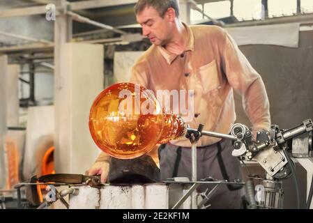 Transformer une masse chaude de verre tirée d'un four chaud en une œuvre d'art le processus de fabrication du verre de près. Moser Glass Factory en République tchèque Banque D'Images