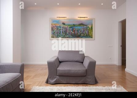 décor intérieur minimaliste, salon d'appartement moderne avec grand fauteuil et peinture sur un mur, lumière du jour, vue de face, avec copie sp Banque D'Images