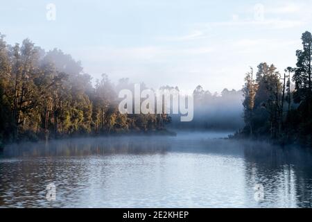 Brume matinale s'élevant au-dessus de la rivière Arnold et forêt indigène à Moana près du lac Brunner, Île du Sud, Nouvelle-Zélande Banque D'Images