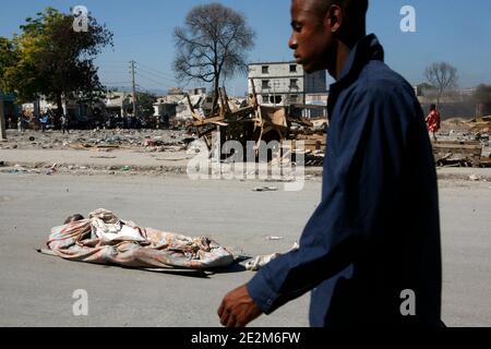 Un corps d'homme se trouve dans la rue, au moment où les gens passent, dans le centre-ville de Port-au-Prince, en Haïti, le 21 janvier 2010. De nombreuses vies ont été perdues lorsqu'un tremblement de terre a dévasté Haïti le mardi 12 janvier. Photo de Sophia Paris/un via ABACAPRESS.COM Banque D'Images