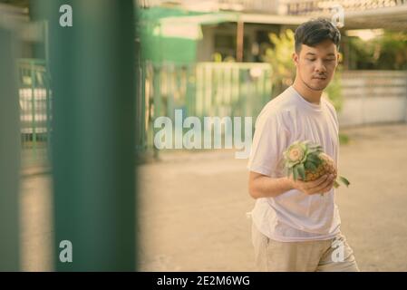Young Asian man ananas à la maison Banque D'Images