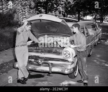 ANNÉES 1950 DEUX ADOLESCENTS TRAVAILLANT SOUS LE CAPOT DE LA VOITURE FORD UNE LECTURE DU MAGASIN À TIGE CHAUDE SECONDE MAIN SUR LE MOTEUR ÉRAFLER TÊTE PERPLEXE - J96 HAR002 HARS VÉHICULE AMI MOTEUR TRAVAIL D'ÉQUIPE DIFFICULTÉ FORD COTON CAPUCHE VIE SATISFACTION FRÈRES MAISON VIE COPIE ESPACE AMITIÉ PERSONNES PLEINE LONGUEUR INSPIRATION AUTOMOBILE HOMMES ADOLESCENT GARÇON MÉCANIQUE ROD SIRS DENIM TRANSPORT B&W OBJECTIFS PERPLEXES RÊVES GRAND ANGLE AVENTURE DÉCOUVERTE AUTOMOBILE SAVOIR INNOVATION MÉCANIQUE FIERTÉ DE SUR LE HAUT LES ENFANTS CONCEPTUELS AUTOMOBILES AMICALES RAYANT DEUXIÈME VÉHICULE ADOLESCENT JEANS BLEU COOPÉRATION CRÉATIVITÉ HOT ROD Banque D'Images