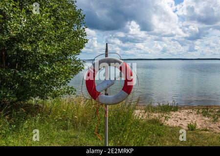 Belle vue sur le paysage de la côte Baltique. Bouée de sauvetage à la surface de l'eau et ciel nuageux. Suède. Banque D'Images