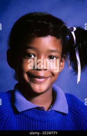 PORTRAIT DES ANNÉES 1980 D'UNE FILLE AFRO-AMÉRICAINE SOURIANTE PORTANT UN CHANDAIL VIOLET À LA RECHERCHE À LA CAMÉRA - KJ11306 TRA001 HARS SATISFACTION FEMMES STUDIO TOURNÉ SANTÉ ESPACE COPIE PERSONNES ENFANTS CONFIANCE RÉFLÉCHIE AMÉRICAINS CONTACT VISUEL RÊVES JOLI BONHEUR TÊTE ET ÉPAULES JOYEUX AFRO-AMÉRICAINS ETHNIE AFRO-AMÉRICAINE DIVERSITÉ AFRO-FIERTÉ AMÉRICAINE AFRO-AMÉRICAINS QUEUE DE CHEVAL SOURIT LES NOIRS EN GROS PLAN JOYEUSE SINCÈRE CROISSANCE CONCENTRÉE CHEVEUX RUBAN JEUNES AVANT L'ADOLESCENCE AVANT LA JEUNE FILLE ARNEST VIEUX LES AFRO-AMÉRICAINS À LA MODE Banque D'Images