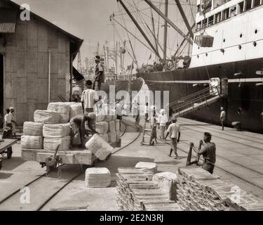GROUPE DE STEVEDORES DES ANNÉES 1930 CHARGEANT DU CAOUTCHOUC ET DU TIN SUR LE NAVIRE OCEAN VA CARGO POUR L'EXPORTATION AUX ÉTATS-UNIS À PENANG MALAISIE - Q409 HAR001 HARS CHARGEMENT DE TRAIN COMPÉTENCE GRAND ANGLE COMPÉTENCES PROFESSIONNELLES FORCE ET TRAVAIL EXTÉRIEUR DANS DE À EMPLOIS PENANG CONCEPTUEL DÉBARDEURS EMPLOYÉ CARGO EXPORTATION CHARGÉ MALAISIE HOMME MOYEN-ADULTE HOMME MOYEN-ADULTE EXPÉDITION STEVEDORES FRONT DE MER JEUNE ADULTE HOMME NOIR ET LE HAR001 BLANC LABOURANT UN VAISSEAU À L'ANCIENNE Banque D'Images