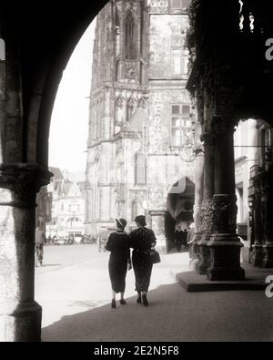 ANNÉES 1930 DEUX FEMMES ANONYMES SILHOUETÉES MARCHANT DANS L'OMBRE D'UN ARCHE VERS UNE ÉGLISE DANS LE PRINZIPALMARKT MUNSTER ALLEMAGNE - R6983 HAR001 HARS PERSONNES BÂTIMENTS SILHOUETTES VERS L'EUROPE CONTOUR B&W. TIME OFF STRUCTURE AVENTURE ARCH PROPRIÉTÉ EUROPÉENNE SILHOUETTED VOYAGE ESCAPADE TOURISME CATHÉDRALE VACANCES TOURISTES IMMOBILIER MUNSTER STRUCTURES EDIFICE ANONYME VACANCES NOIR ET BLANC HAR001 À L'ANCIENNE Banque D'Images