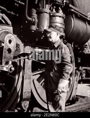 HOMME DES ANNÉES 1920 MÉCANICIEN DE LOCOMOTIVE DE CHEMIN DE FER ROULANT EN TRAIN DE SE CONNECTER TIGES SUR LE MOTEUR À VAPEUR AVANT DE COMMENCER LA JOURNÉE DE TRAVAIL - R7781 HAR001 HARS SATISFACTION EMPLOIS RURAL COPY ESPACE DEMI-LONGUEUR PERSONNES TRANSPORT DE CONFIANCE DES HOMMES B&W D'ÂGE MOYEN HOMME D'ÂGE MOYEN RAIL AVANT OCCUPATION PROTECTION FORCE CONNAISSANCE POUVOIR PUISSANT DE FIERTÉ DU TRAVAIL EMPLOI LOCOMOTIVE OCCUPATIONS ENTRETIEN DES CONNEXIONS CONCEPTUEL MAINTENIR L'ÉLÉGANCE DES CHEMINS DE FER DE CONNEXION LES EMPLOYÉS DE LA PRÉCISION DE LUBRIFICATION TIGES COMMENÇANT NOIR ET BLANC D'ORIGINE CAUCASIENNE HAR001 LABIING ANCIEN VÊTEMENTS DE TRAVAIL Banque D'Images