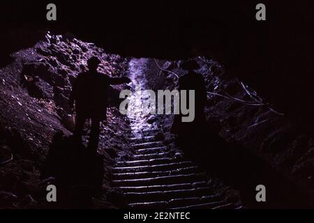 Silhouette de l'homme et de la femme qui se promo dans une grotte Banque D'Images