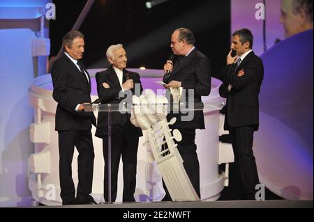 Le chanteur français Charles Aznavour (flanqué de Michel Drucker et Nagui) reçoit un prix d'hommage du ministre français de la culture Frédéric Mitterrand lors de la 25e cérémonie des "victoires de la musique" qui s'est tenue à la salle Zenith à Paris, France, le 6 mars 2010. Photo de Christophe Guibbbaud/ABACAPRESS.COM Banque D'Images
