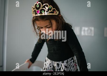 fille de 4 ans vêtue de tiara regardant vers le bas Banque D'Images
