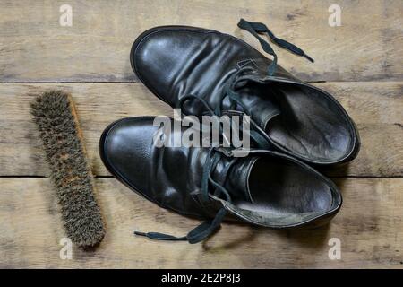 vieilles chaussures en cuir avec cirage de chaussures et brosses contre les personnes âgées panneaux en bois fissurés Banque D'Images