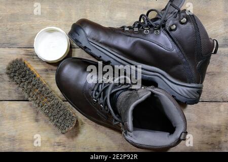 vieilles chaussures en cuir avec cirage de chaussures et brosses contre les personnes âgées panneaux en bois fissurés Banque D'Images