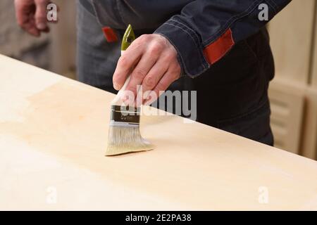 Menuisier au travail. Gros plan de la surface en bois de couverture avec un espace de copie vernis Banque D'Images