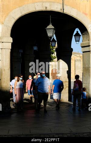 Piétons marchant sous les arcades de la place Santa Teresa de Jesús à Ávila. Banque D'Images