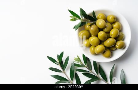 Branches d'olive aux olives salées placées sur un fond blanc avec espace de copie. Vue de dessus Banque D'Images